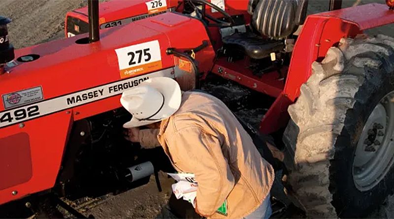Inspektion eines gebrauchten Massey Ferguson Traktors bei einer Auktion.